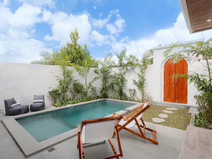 Private pool with deck chairs and garden